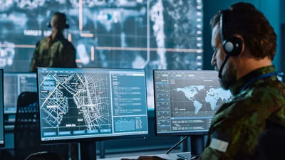 Analyst working at a computer with data visualizations